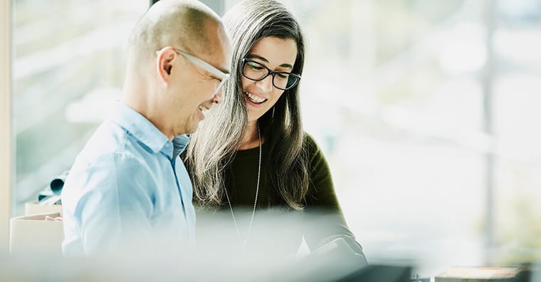 man and woman looking at tablet