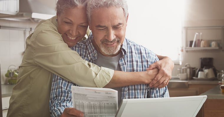 happy couple looking at medical bill