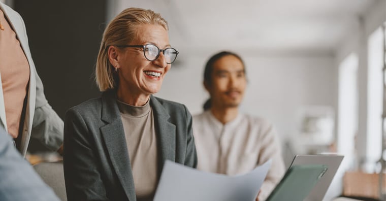Confident healthcare leader holding a document and smiling
