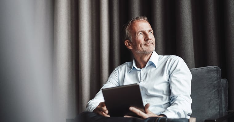 healthcare executive holding an ipad and looking off into the distance