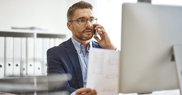 Business man on the phone reviewing a document