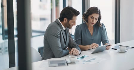two business professionals analyzing data