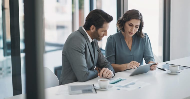 two business professionals analyzing data