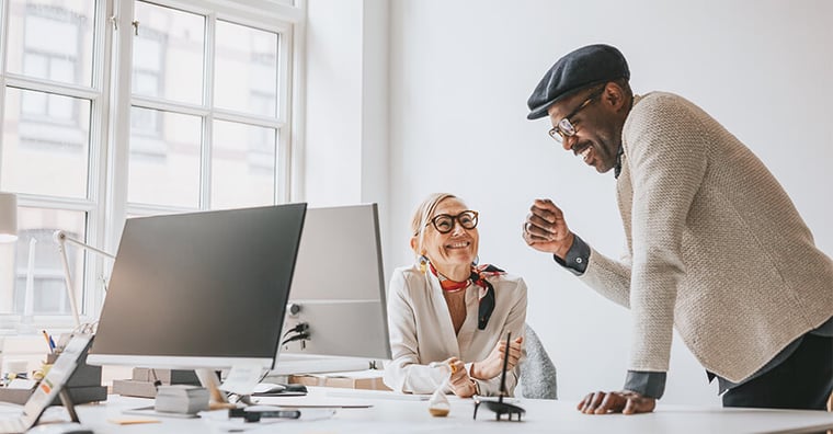two happy colleagues near a computer