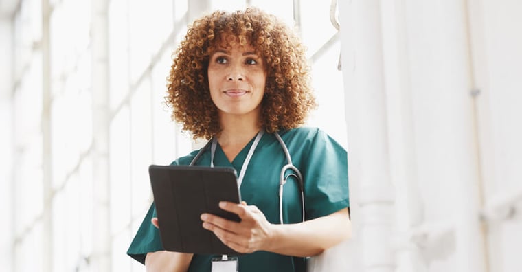 Nurse holding iPad and smiling
