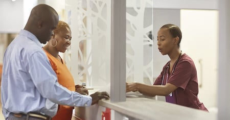 patients speaking with front desk at hospital