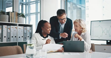 Three colleagues looking at laptop