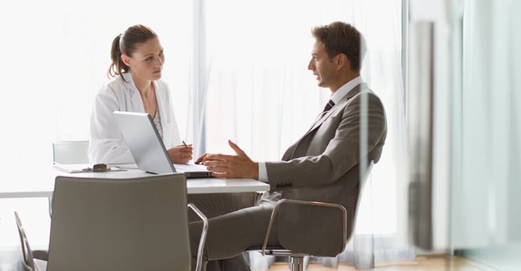 doctor and business professional reviewing analytics on computer