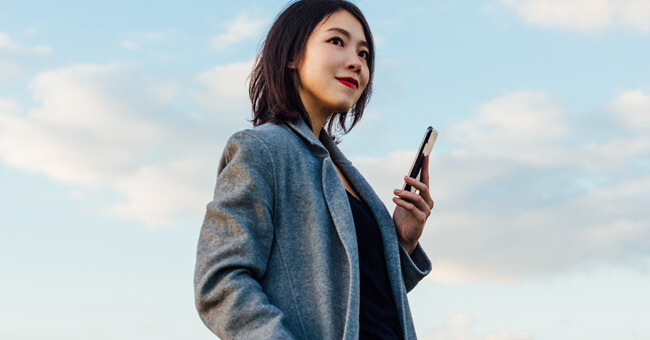 smiling woman holding mobile device
