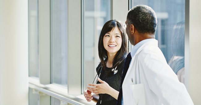 two health professionals talking in a hallway